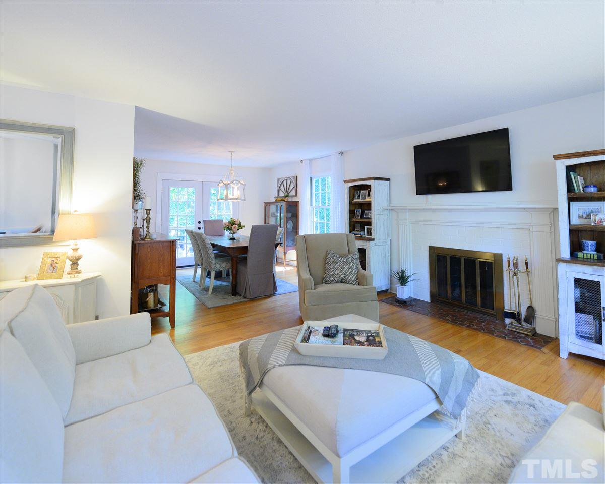 4917 Oak Park Road Raleigh, NC 27612 - Photo 2 of 25 a living room with furniture a flat screen tv and a fireplace