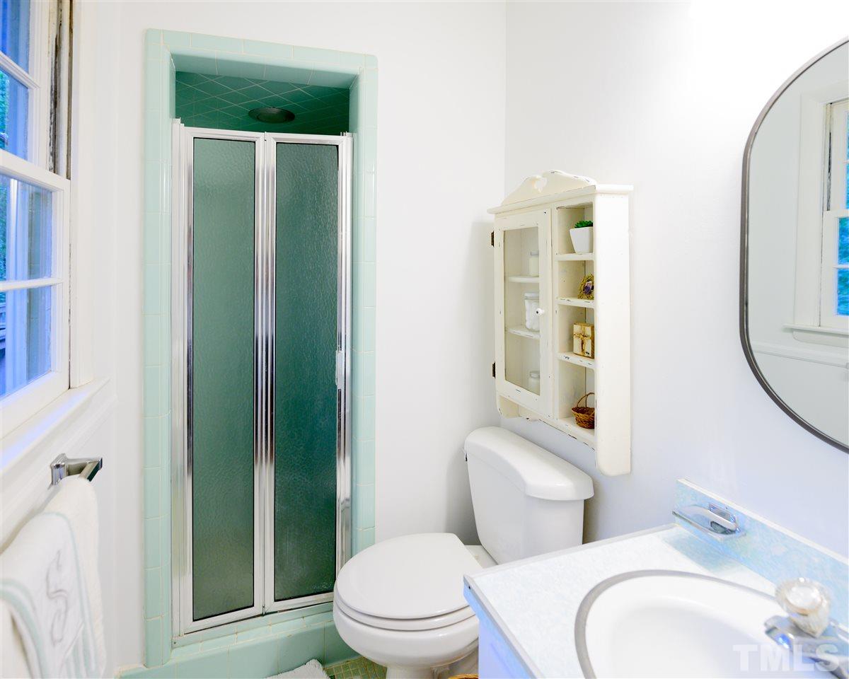 4917 Oak Park Road Raleigh, NC 27612 - Photo 11 of 25 a white toilet sitting next to a bathroom sink and a mirror