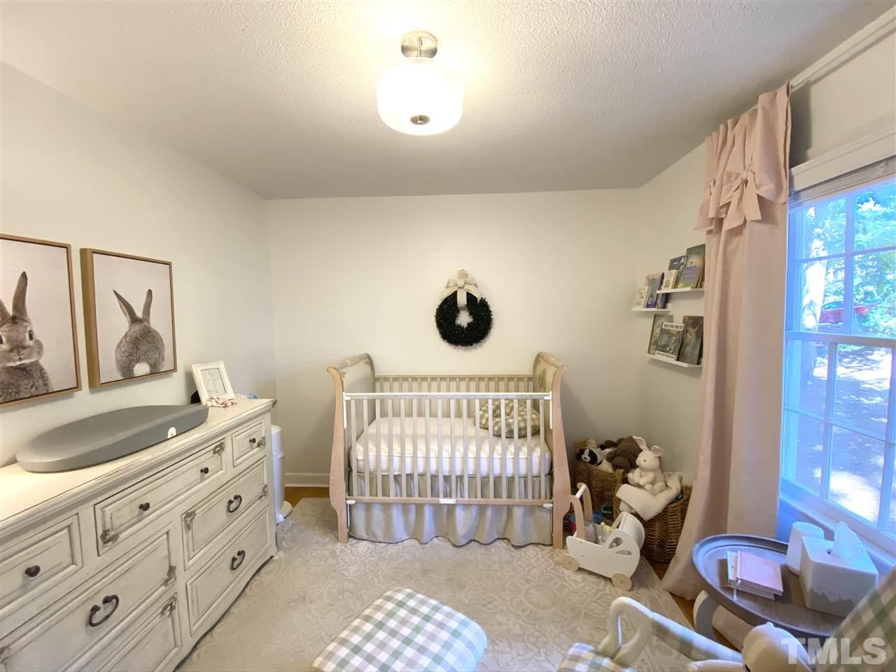 4917 Oak Park Road Raleigh, NC 27612 - Photo 13 of 25 a bedroom with a bed and a dresser