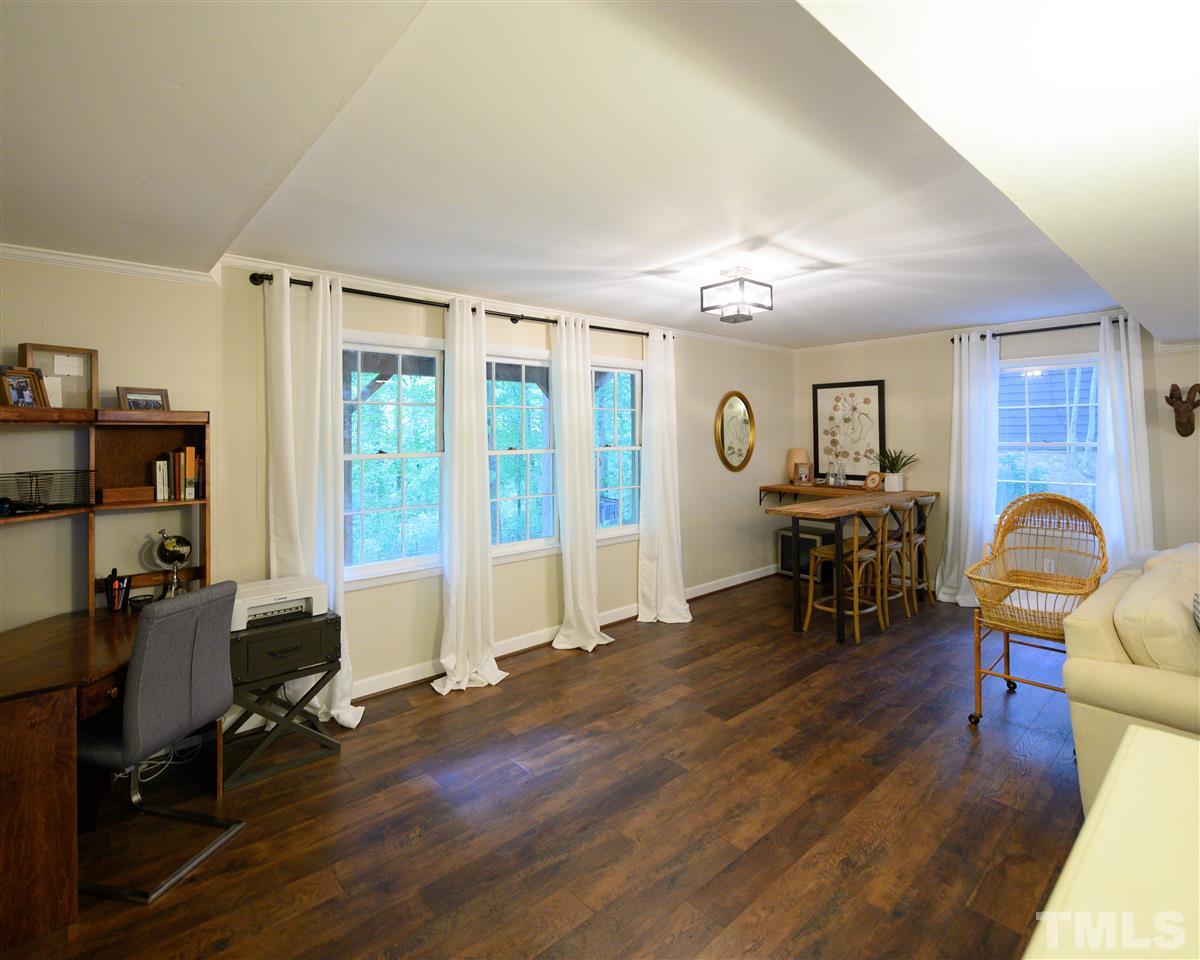 4917 Oak Park Road Raleigh, NC 27612 - Photo 14 of 25 a living room with furniture a piano and floor to ceiling window