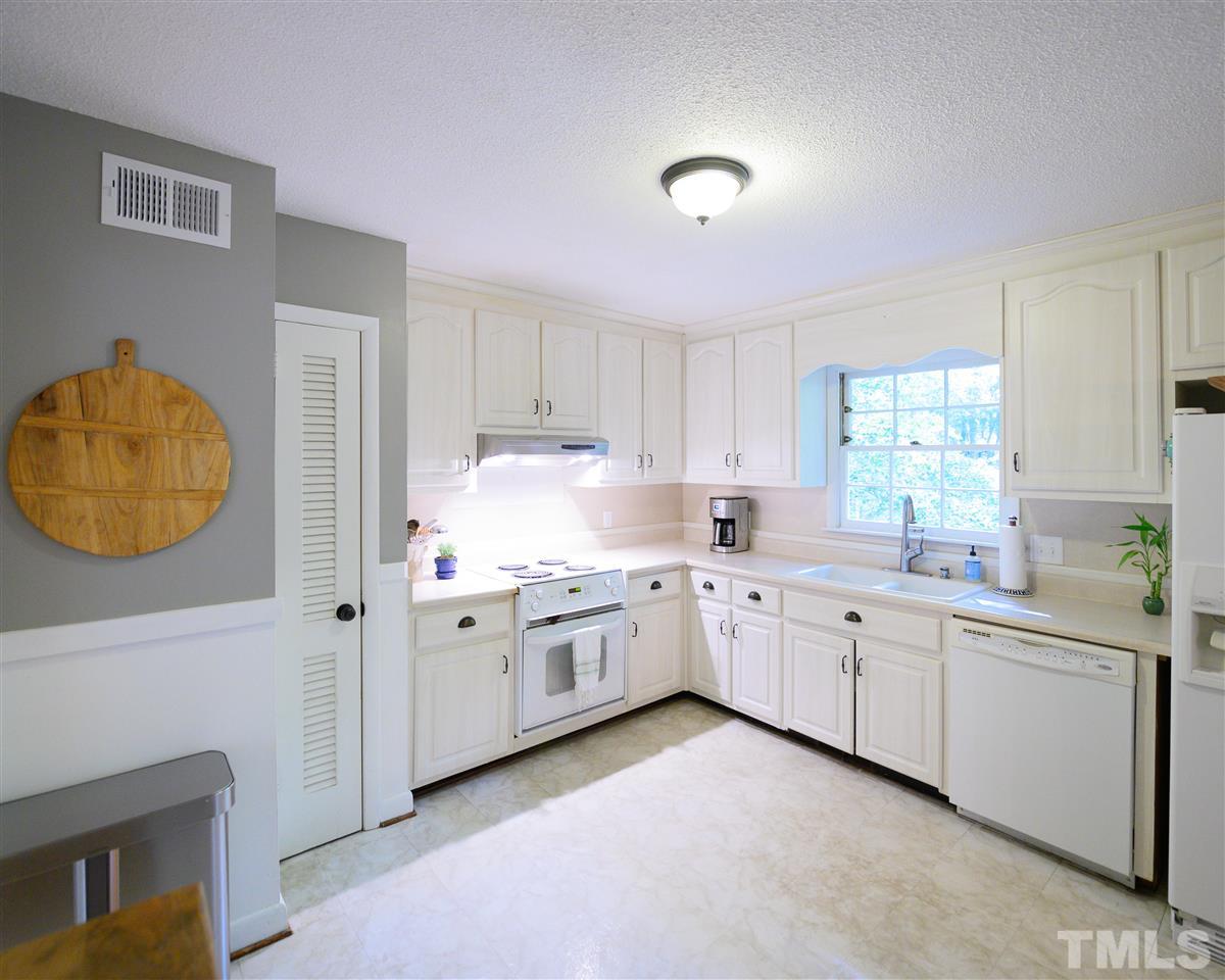 4917 Oak Park Road Raleigh, NC 27612 - Photo 5 of 25 a kitchen with sink cabinets and window