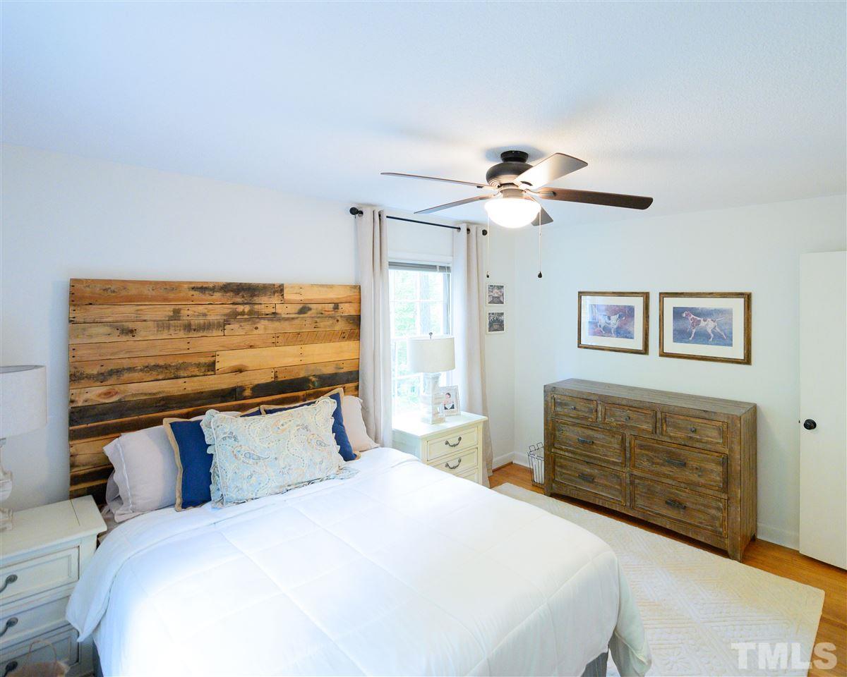 4917 Oak Park Road Raleigh, NC 27612 - Photo 7 of 25 a bedroom with a bed and a chandelier