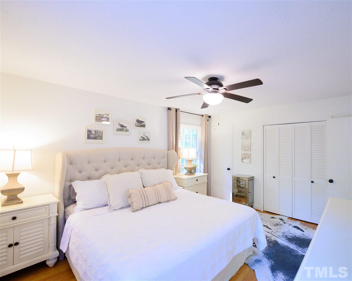4917 Oak Park Road Raleigh, NC 27612 - Photo 10 of 25 a bedroom with a bed and a chandelier