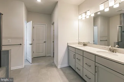 a spacious bathroom with double vanity and a mirror