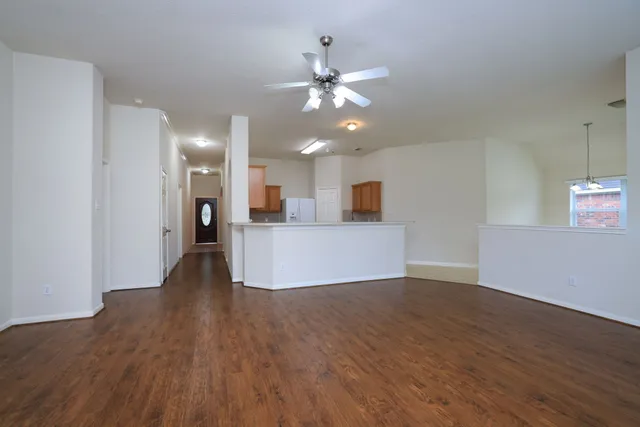 a view of a kitchen with wooden floor and a ceiling fan