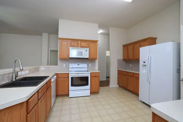 a kitchen with stainless steel appliances granite countertop a refrigerator stove and sink