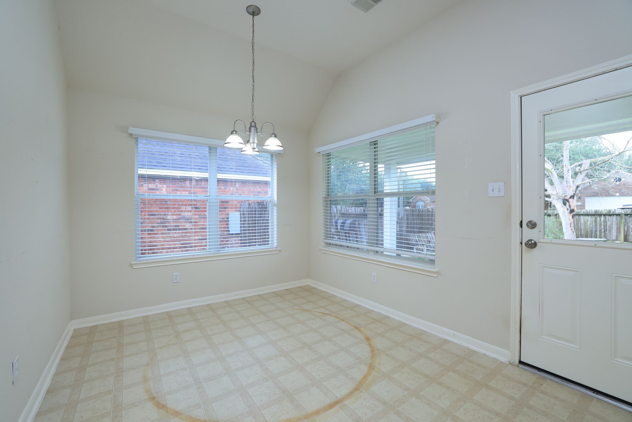 30515 Red Bluff Circle Magnolia, TX 77355 - Photo 14 of 28 Bright breakfast area with large windows, tile flooring, and a ceiling light fixture. Includes a door leading to the backyard, providing natural light and outdoor access.
