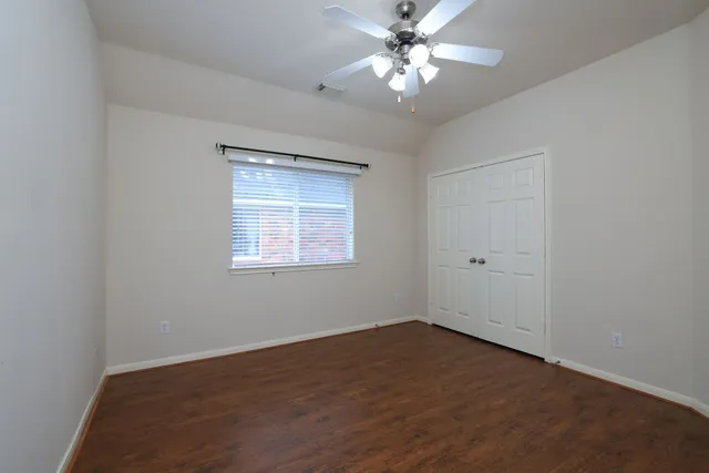 an empty room with a window and a fan