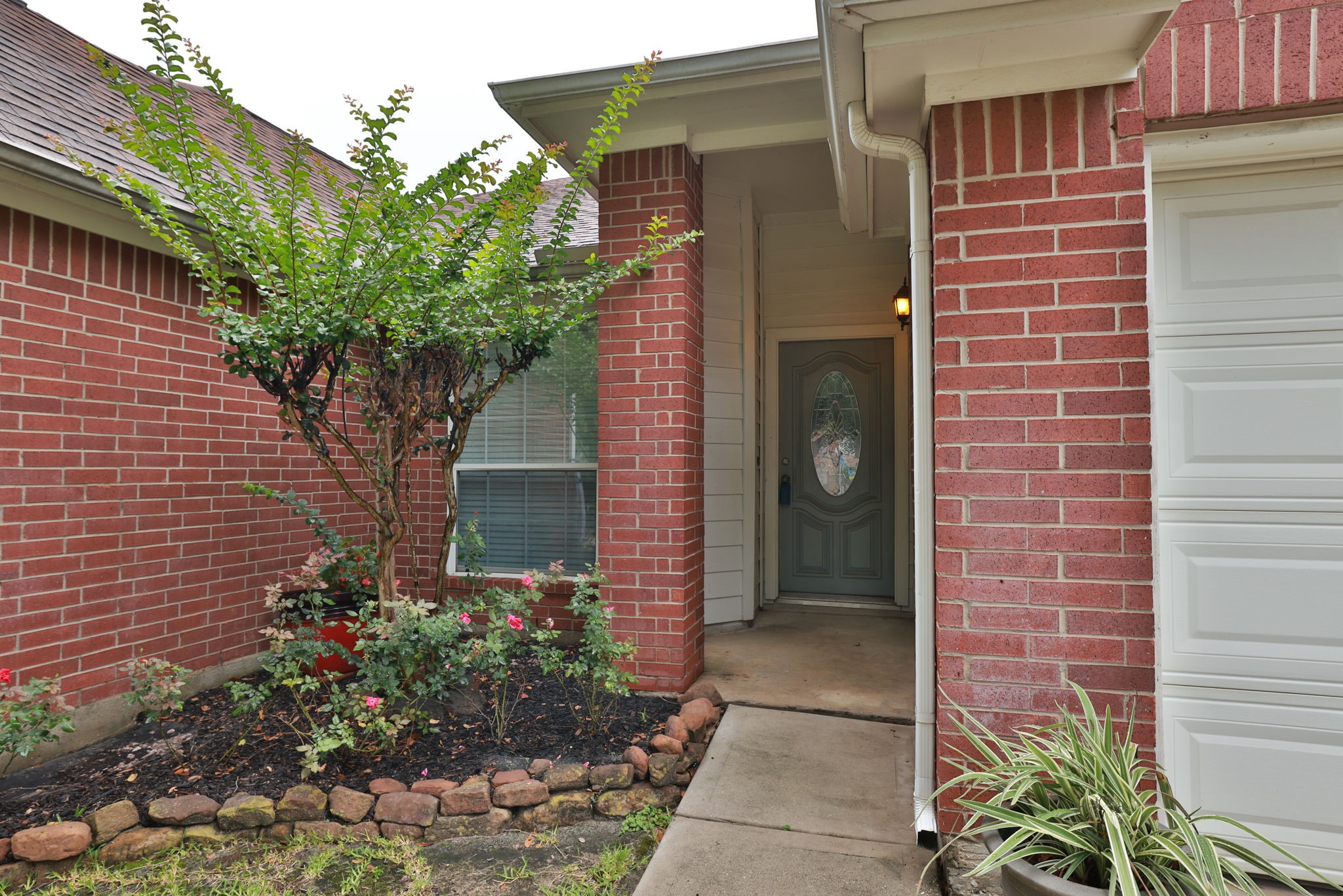 30515 Red Bluff Circle Magnolia, TX 77355 - Photo 4 of 28 Beautiful brick exterior with a welcoming front entrance, featuring a neat garden bed and a stylish front door. Perfect for a cozy and inviting home atmosphere.