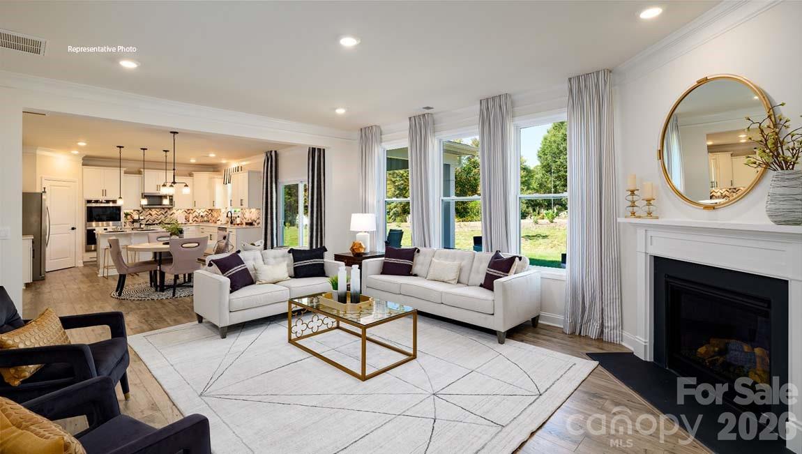 107 Rhuidean Court Troutman, NC 28166 - Photo 12 of 44 a living room with furniture a fireplace a lamp and a large window