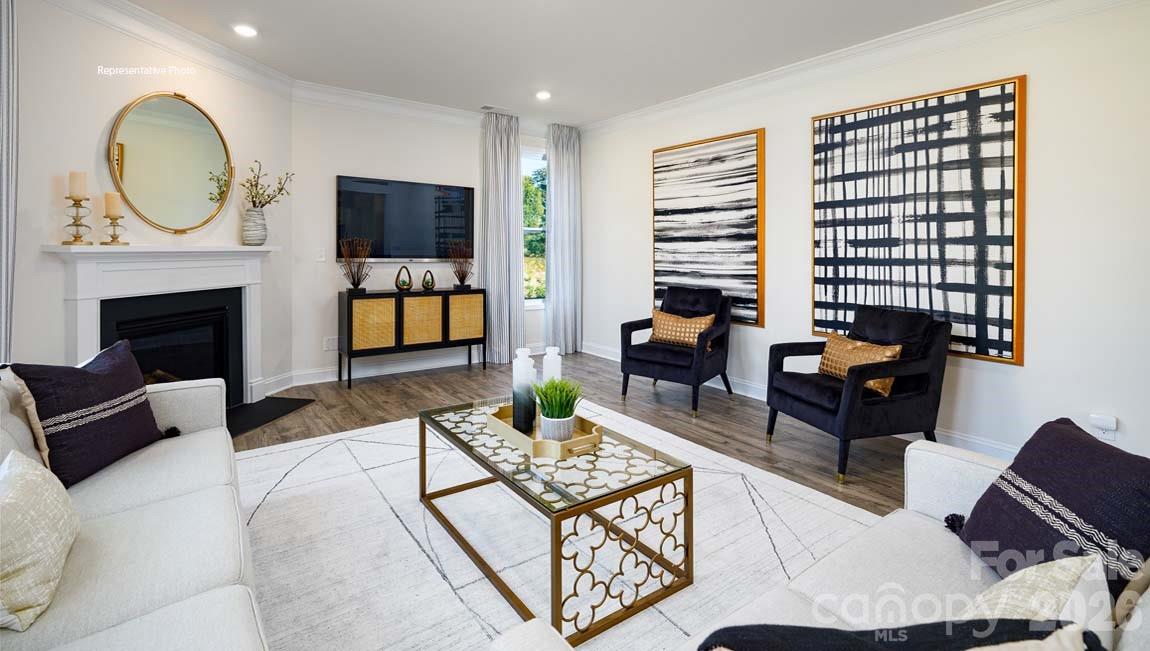 107 Rhuidean Court Troutman, NC 28166 - Photo 13 of 44 a living room with furniture a fireplace and a flat screen tv