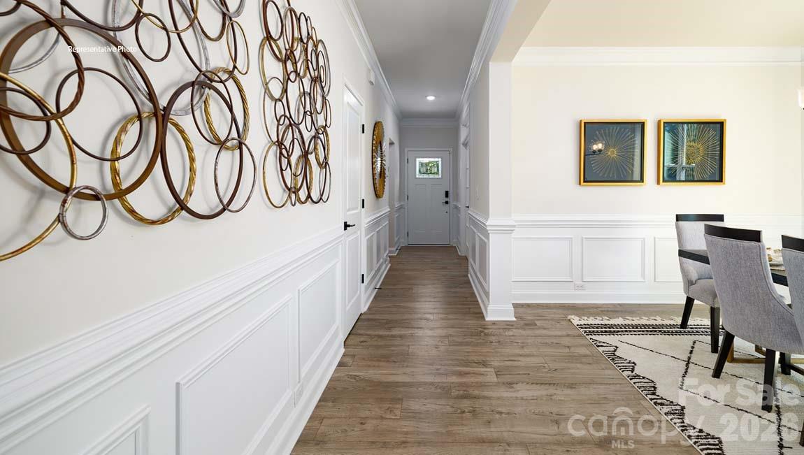 107 Rhuidean Court Troutman, NC 28166 - Photo 2 of 44 a hallway with wooden floor and table and chairs