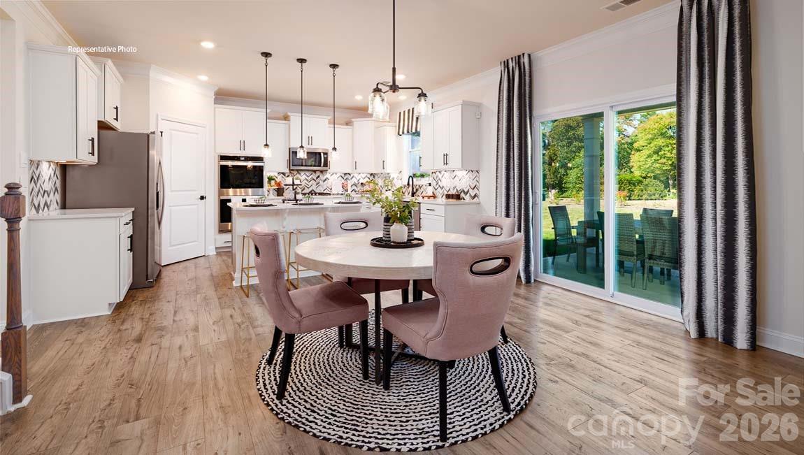 107 Rhuidean Court Troutman, NC 28166 - Photo 7 of 44 a view of a dining room with furniture window and wooden floor
