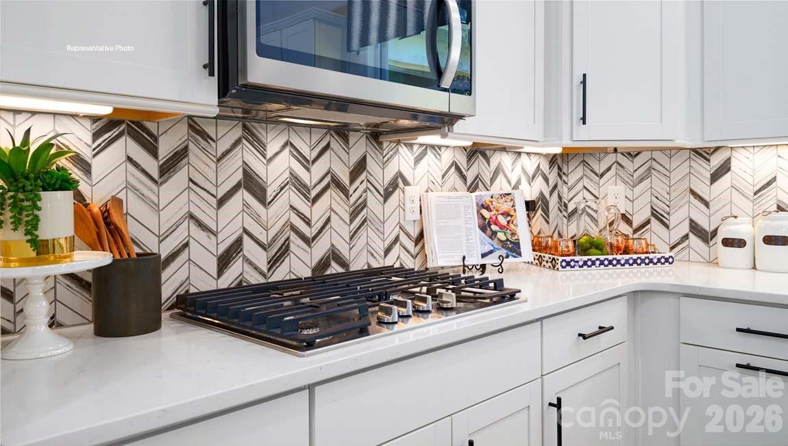 107 Rhuidean Court Troutman, NC 28166 - Photo 8 of 44 a kitchen with a stove and a white cabinets