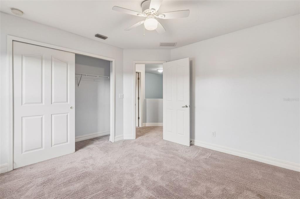 25134 Palisade Road Punta Gorda, FL 33983 - Photo 38 of 58 an empty room with a ceiling fan and a bathroom