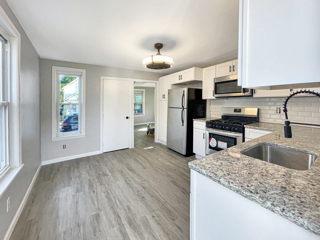 12 Ladd Street Springfield, MA 01109 - Photo 22 of 37 a kitchen with stainless steel appliances granite countertop a sink refrigerator and microwave
