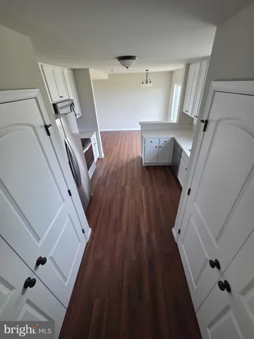 a view of a livingroom with wooden floor and staircase