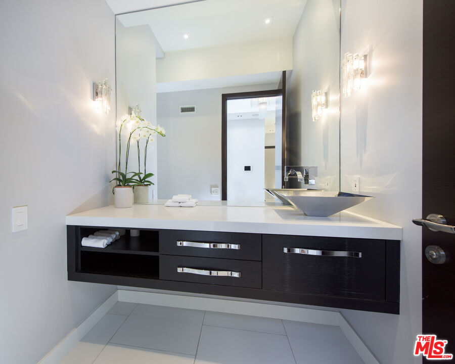 900 North Hillcrest Road Beverly Hills, CA 90210 - Photo 35 of 39 a bathroom with a sink and a mirror