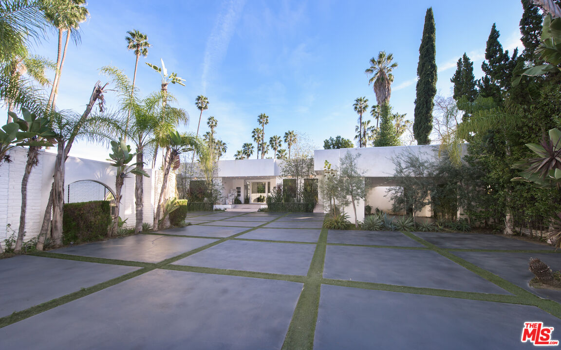 900 North Hillcrest Road Beverly Hills, CA 90210 - Photo 4 of 39 a front view of a house with a yard and tree s