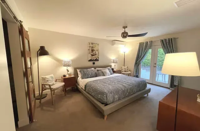 a spacious bedroom with a bed window and a lamp