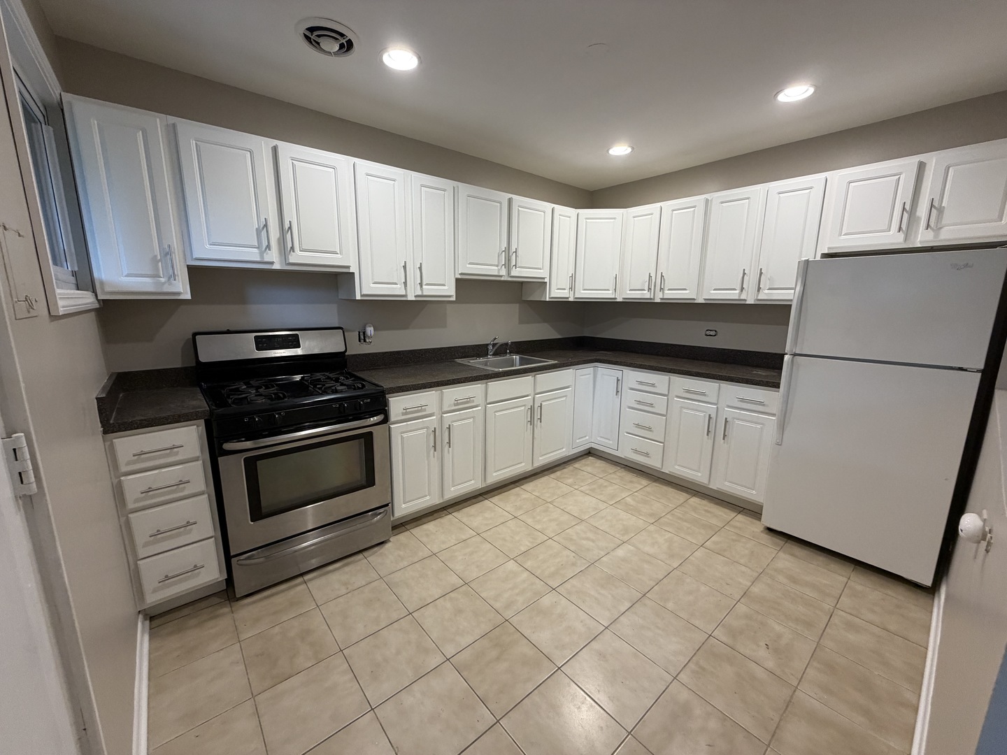1605 Monroe Street, Unit 1 Evanston, IL 60202 - Photo 2 of 14 a kitchen with granite countertop white cabinets and white appliances