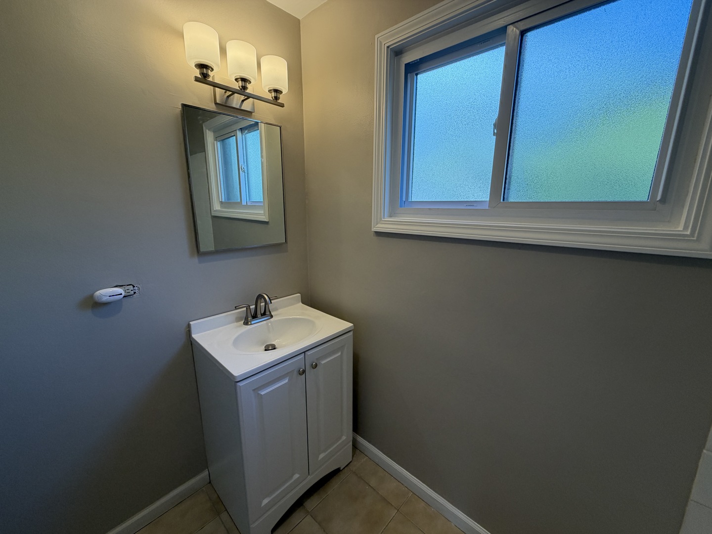 1605 Monroe Street, Unit 1 Evanston, IL 60202 - Photo 5 of 14 a bathroom with a sink a mirror and vanity