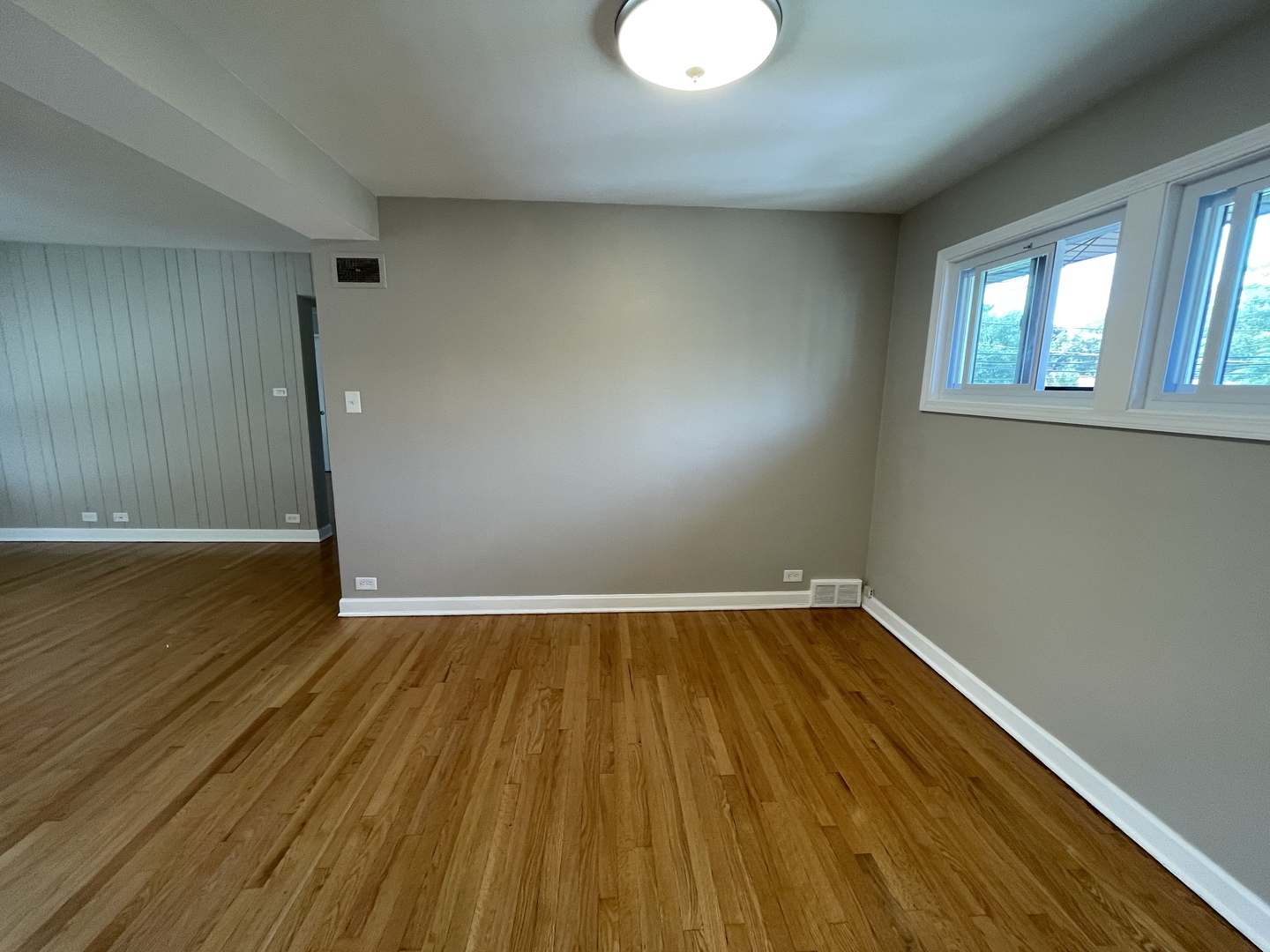 1605 Monroe Street, Unit 1 Evanston, IL 60202 - Photo 10 of 14 an empty room with wooden floor and windows