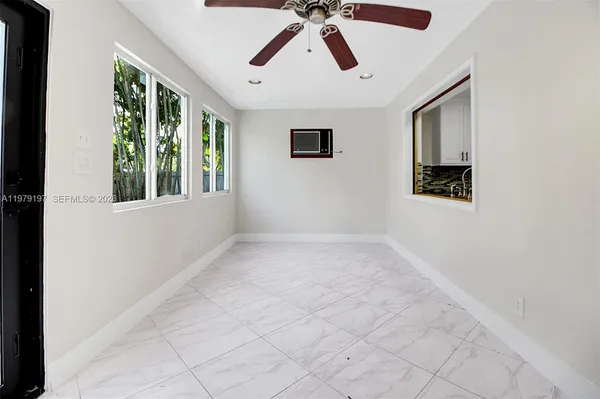 a view of a hallway with wooden floor and a mirror