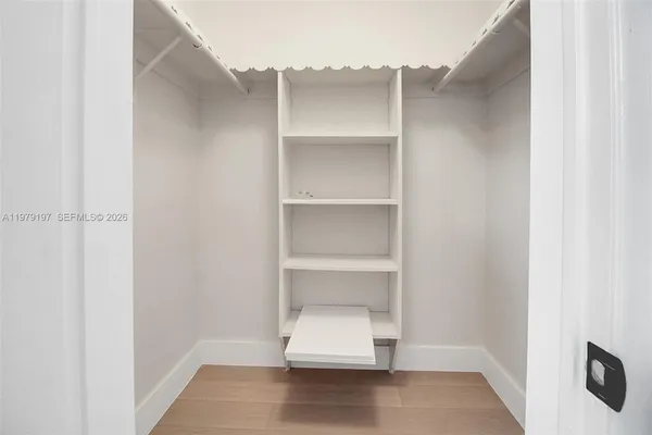 an empty room with closet and windows