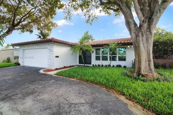 a view of a house with a tree in the yard