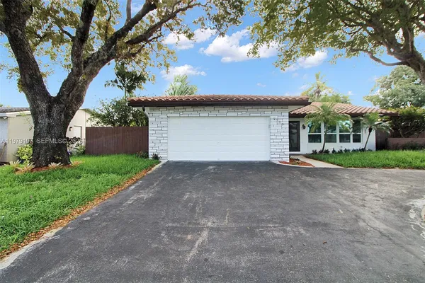 a view of a house with a tree in front of it