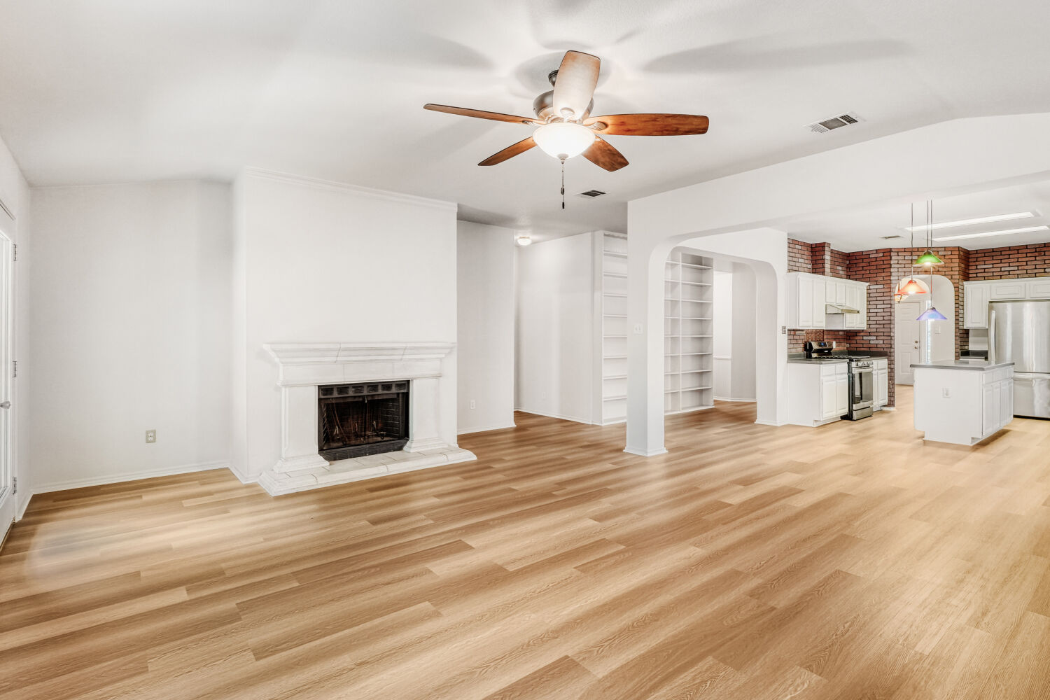 1205 Machado Road Cedar Park, TX 78613 - Photo 15 of 30 a view of a livingroom with a fireplace a ceiling fan and kitchen view