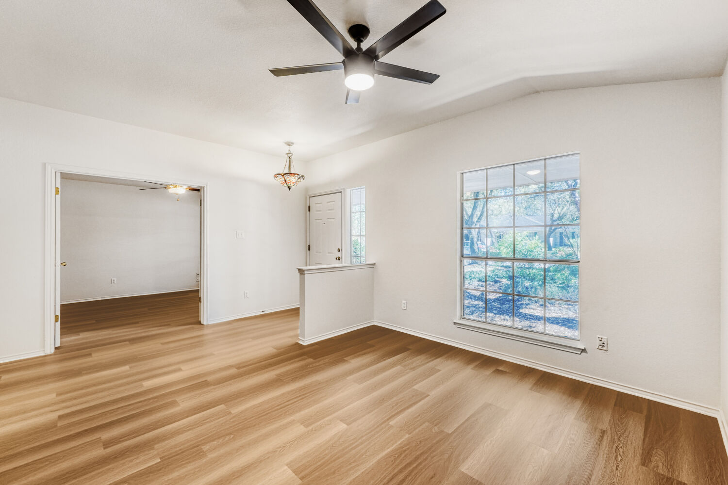 1205 Machado Road Cedar Park, TX 78613 - Photo 7 of 30 an empty room with wooden floor chandelier fan and windows