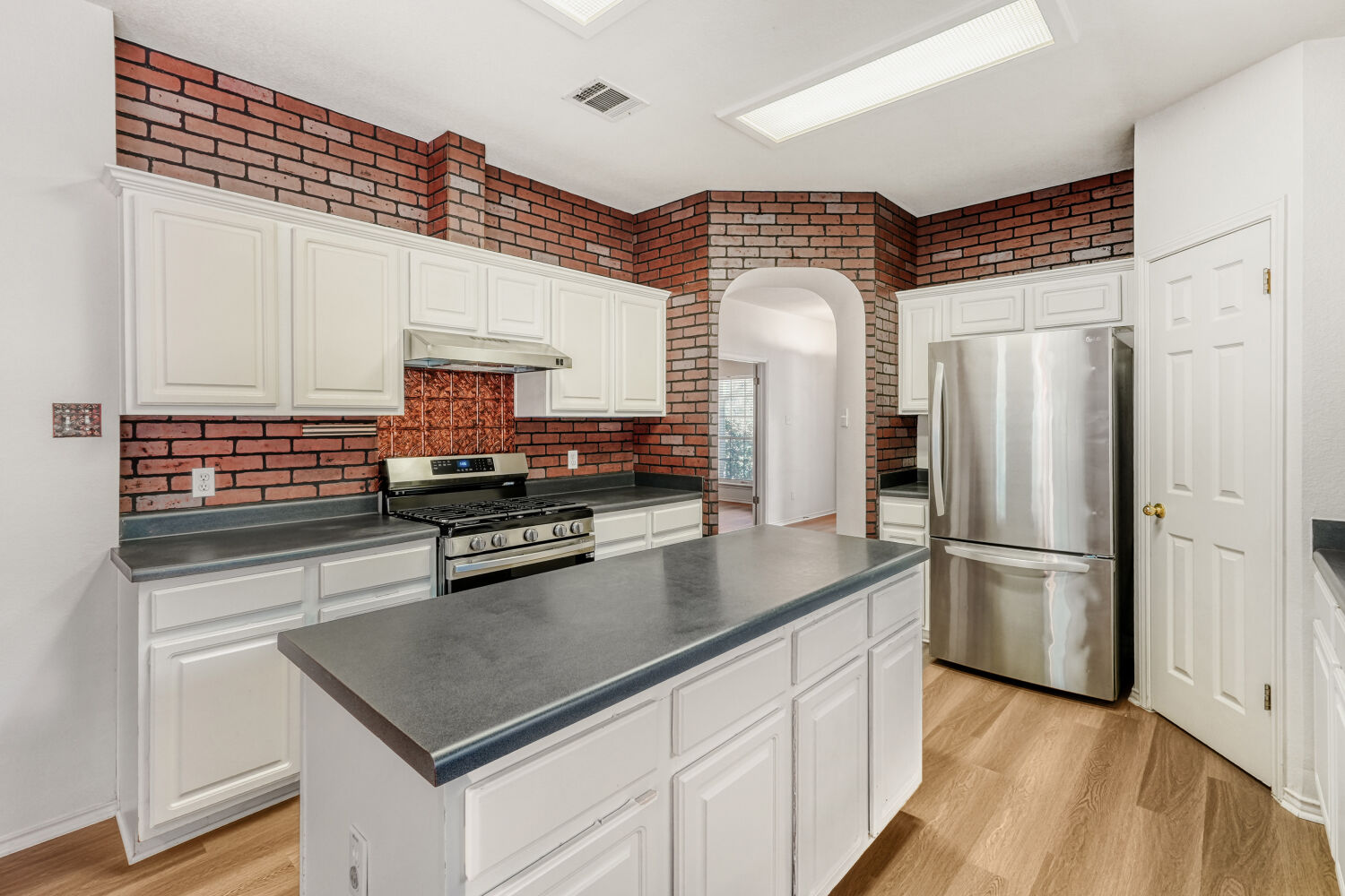 1205 Machado Road Cedar Park, TX 78613 - Photo 9 of 30 a kitchen with stainless steel appliances a sink cabinets and wooden floor