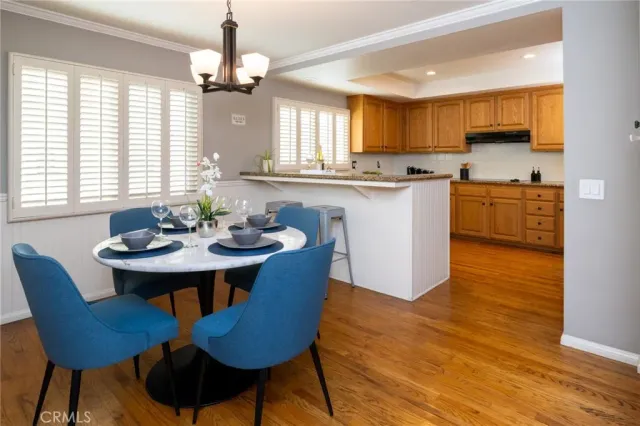 a kitchen with a dining table chairs and sink