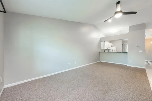 an empty room with a empty space and a kitchen view