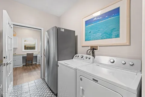 a view of washer and dryer with bathroom in the background