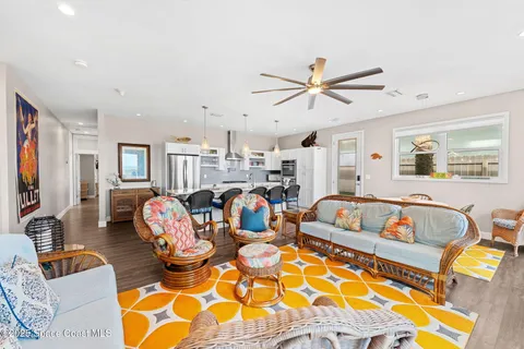 a living room with furniture kitchen view and a large window