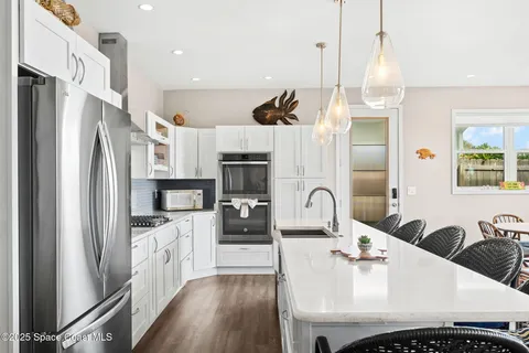 a view of kitchen with refrigerator and wooden floor