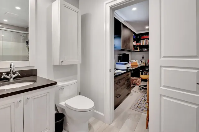 a bathroom with a toilet a sink and mirror
