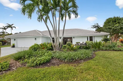 a front view of a house with a yard and potted plants