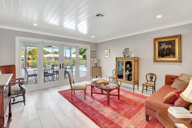 a dining room with wooden floor a chandelier a wooden table and chairs