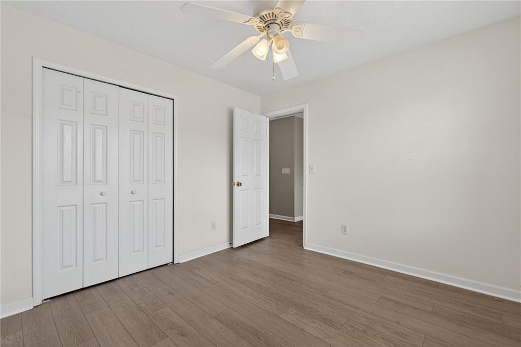 45 Polo Fields Northeast Cartersville, GA 30121 - Photo 39 of 49 an empty room with wooden floor chandelier fan and closet area