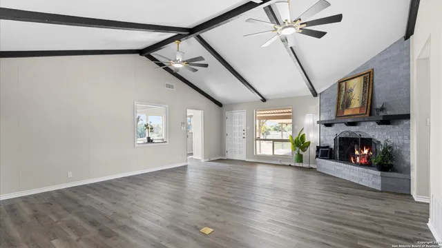 a view of an empty room with a fireplace and a window