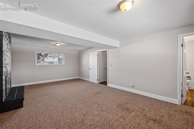 6319 Chippewa Road Colorado Springs, CO 80915 - Photo 32 of 36 Basement with carpet and a brick fireplace