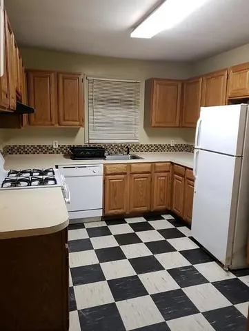 a kitchen with a checkered floor and white cabinets