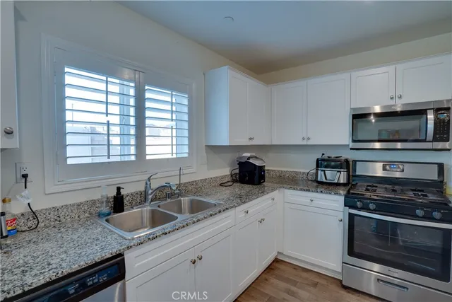 a kitchen with granite countertop a sink and a stove top oven