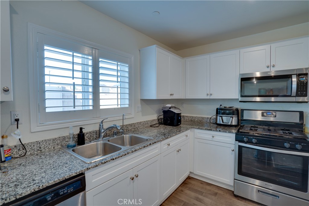 1328 Prosperity Place Hemet, CA 92543 - Photo 11 of 40 a kitchen with granite countertop a sink and a stove top oven
