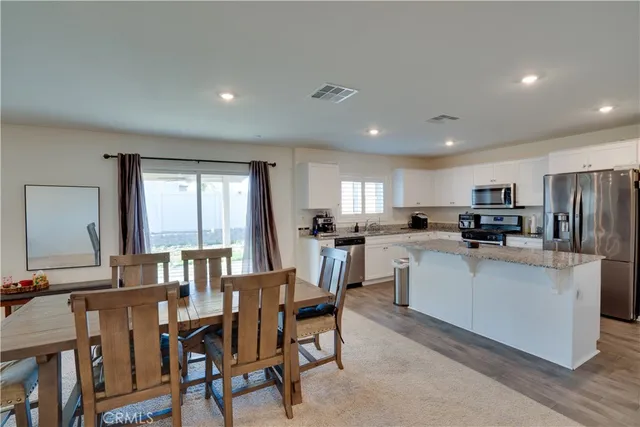 a view of kitchen with refrigerator dining table and chairs