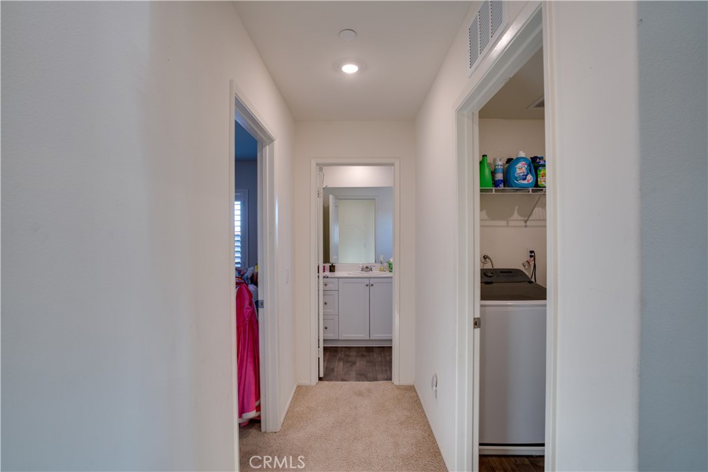 1328 Prosperity Place Hemet, CA 92543 - Photo 25 of 40 a view of hallway with walk in closet and wooden floor